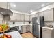 Modern kitchen with stainless steel appliances, light gray cabinets, and white subway tile backsplash at 201 Wright St # 106, Lakewood, CO 80228
