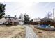Expansive backyard with a fire pit, stone path, mature trees, and a deck is perfect for relaxation and outdoor activities at 13055 E Dakota Ave, Aurora, CO 80012