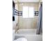 Bright bathroom featuring a shower and tub with decorative tile accents and a large window for natural light at 13055 E Dakota Ave, Aurora, CO 80012