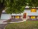 Charming home featuring a well-maintained lawn, garden beds and brick accents at 13055 E Dakota Ave, Aurora, CO 80012