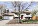 An inviting front exterior showcases a charming two-story home with a well-maintained yard and beautiful tree at 13055 E Dakota Ave, Aurora, CO 80012