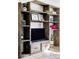 Stylish living room featuring custom built-in shelving, modern TV setup, and warm wood floors at 13055 E Dakota Ave, Aurora, CO 80012