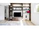 Stylish living room with custom built-in shelving, modern TV setup and wood floors that add warmth and character at 13055 E Dakota Ave, Aurora, CO 80012