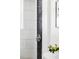 Modern shower featuring stone column, contrasting white tile, and sleek fixtures at 13055 E Dakota Ave, Aurora, CO 80012