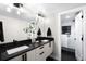A modern bathroom features double sinks, granite countertops, sleek fixtures, and a walk-in shower with modern tiling at 2179 S Bannock St, Denver, CO 80223