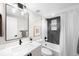 A well-lit bathroom features a large mirror, sleek vanity, and a shower-tub combo with modern tile at 2179 S Bannock St, Denver, CO 80223