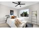 A bright bedroom features a large window, ceiling fan, and comfortable decor at 2179 S Bannock St, Denver, CO 80223