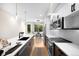 Bright kitchen with quartz counters, stainless appliances, and open layout dining area at 2179 S Bannock St, Denver, CO 80223