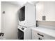 Bright laundry area features stacked washer and dryer with modern white cabinetry and countertop for added convenience at 2179 S Bannock St, Denver, CO 80223