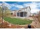 Landscaped backyard featuring a well-maintained lawn and a screened-in porch, perfect for outdoor relaxation and entertaining at 7844 Grady Cir, Castle Rock, CO 80108