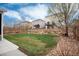 Spacious backyard with a mix of green lawn, rock landscaping, and a wooden fence at 7844 Grady Cir, Castle Rock, CO 80108