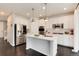 A bright kitchen featuring white cabinets, stainless steel appliances, a center island, and modern pendant lighting at 7844 Grady Cir, Castle Rock, CO 80108