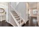 Bright stairway with white railing, carpeted steps, and dark hardwood flooring at 7844 Grady Cir, Castle Rock, CO 80108