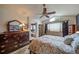 Comfortable bedroom featuring a ceiling fan, large dresser, and a cozy bathroom en suite at 16309 Hedgeway Dr, Parker, CO 80134