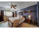 Cozy bedroom with a floral bedspread, decorative shelves, and a large ceiling fan at 16309 Hedgeway Dr, Parker, CO 80134
