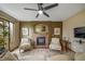 Living room featuring a brick fireplace, olive-colored walls, and a ceiling fan at 16309 Hedgeway Dr, Parker, CO 80134