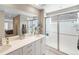 Modern bathroom with double sink vanity, glass-enclosed shower, and neutral color palette at 12845 Park Creek Way Way, Firestone, CO 80504