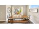 Cozy dining area with a wooden table, bench seating, and natural light from large windows at 12845 Park Creek Way Way, Firestone, CO 80504