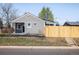 Charming bungalow with grey siding, black trim, a small porch, and a newly installed wooden fence at 190 S Canosa Ct, Denver, CO 80219