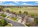 Aerial view of a neighborhood highlighting homes, green spaces, and the surrounding landscape under a blue sky at 6340 E Costilla Pl, Centennial, CO 80112