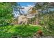 Lush backyard featuring a patio, outdoor seating, and the home's exterior with a covered deck above at 6340 E Costilla Pl, Centennial, CO 80112