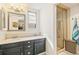 Bathroom featuring a double vanity with dark cabinets and framed mirrors, and a shower stall at 6340 E Costilla Pl, Centennial, CO 80112