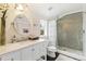 Bathroom with white vanity, an oval mirror, and tiled glass-enclosed shower with rainfall showerhead at 6340 E Costilla Pl, Centennial, CO 80112