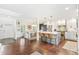 Open-concept kitchen with a center island, bar stools, white cabinets, and stainless steel appliances adjacent to the dining area at 6340 E Costilla Pl, Centennial, CO 80112
