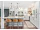 Bright kitchen with island seating, marble counters and backsplash, and stainless steel appliances at 6340 E Costilla Pl, Centennial, CO 80112
