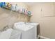 Laundry room with a sink, white washer and dryer, and wire rack shelving for ample storage at 6340 E Costilla Pl, Centennial, CO 80112
