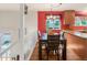 Bright dining area featuring a dark wood table, hardwood floors, and a pop of color from the red accent wall at 3914 E 116Th Pl, Thornton, CO 80233