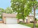 Charming home with a brick and vinyl exterior, lush lawn, mature trees, and attached two-car garage at 3914 E 116Th Pl, Thornton, CO 80233