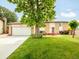 Charming home with a brick and vinyl exterior, lush lawn, mature trees, and attached two-car garage at 3914 E 116Th Pl, Thornton, CO 80233