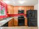 Efficient kitchen with stainless steel appliances, stone countertops and wood cabinets, accented by a bold red wall at 3914 E 116Th Pl, Thornton, CO 80233