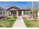 Inviting home featuring a manicured lawn, stone details, and a charming front porch at 19834 W 56Th Pl, Golden, CO 80403