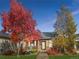Charming single-story home with stone accents and mature trees in a colorful fall setting at 19834 W 56Th Pl, Golden, CO 80403