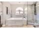 Modern bathroom with a soaking tub, glass-enclosed shower with beautiful stone flooring at 6651 Yale Dr, Highlands Ranch, CO 80130