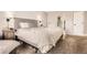 Bright bedroom with a large bed, neutral color palette, and view to the bathroom at 6651 Yale Dr, Highlands Ranch, CO 80130