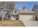 Inviting two-story home with a brick facade, a blue front door, and an attached two-car garage at 6651 Yale Dr, Highlands Ranch, CO 80130
