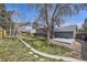 Spacious backyard featuring a grassy lawn, mature tree, deck, and fencing, perfect for outdoor activities at 145 S Buchanan Ave, Louisville, CO 80027