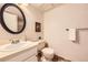 Classic bathroom featuring an oval mirror, vanity with sink, toilet, and decorative artwork at 145 S Buchanan Ave, Louisville, CO 80027