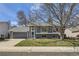 Charming gray two-story home with a well-maintained lawn, mature trees, attached garage and inviting blue front door at 145 S Buchanan Ave, Louisville, CO 80027