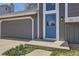 Close up of the gray home's front entryway, highlighting the blue front door and attached garage on a sunny day at 145 S Buchanan Ave, Louisville, CO 80027
