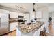 Modern kitchen featuring white cabinets, stainless steel appliances, granite countertops, an island and breakfast bar at 145 S Buchanan Ave, Louisville, CO 80027