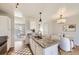 Bright kitchen with an island featuring a sink, granite countertops, white cabinets, and hardwood floors leading to living area at 145 S Buchanan Ave, Louisville, CO 80027