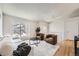 Open-concept living room boasts natural light, hardwood floors, a comfortable sofa, and view from the second floor landing at 145 S Buchanan Ave, Louisville, CO 80027