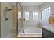 Well-lit bathroom features a soaking tub, glass-enclosed shower, and stylish fixtures at 12054 E Lake Cir, Greenwood Village, CO 80111