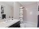 Bathroom with a shower over tub, toilet, sink and a black and white shower curtain providing functionality at 12054 E Lake Cir, Greenwood Village, CO 80111