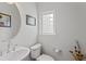 Powder bathroom with pedestal sink, neutral paint, framed art, and unique window for natural light at 12054 E Lake Cir, Greenwood Village, CO 80111