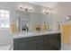Bathroom featuring double sinks, tiled backsplash, large vanity mirror, and modern lighting fixtures at 12054 E Lake Cir, Greenwood Village, CO 80111